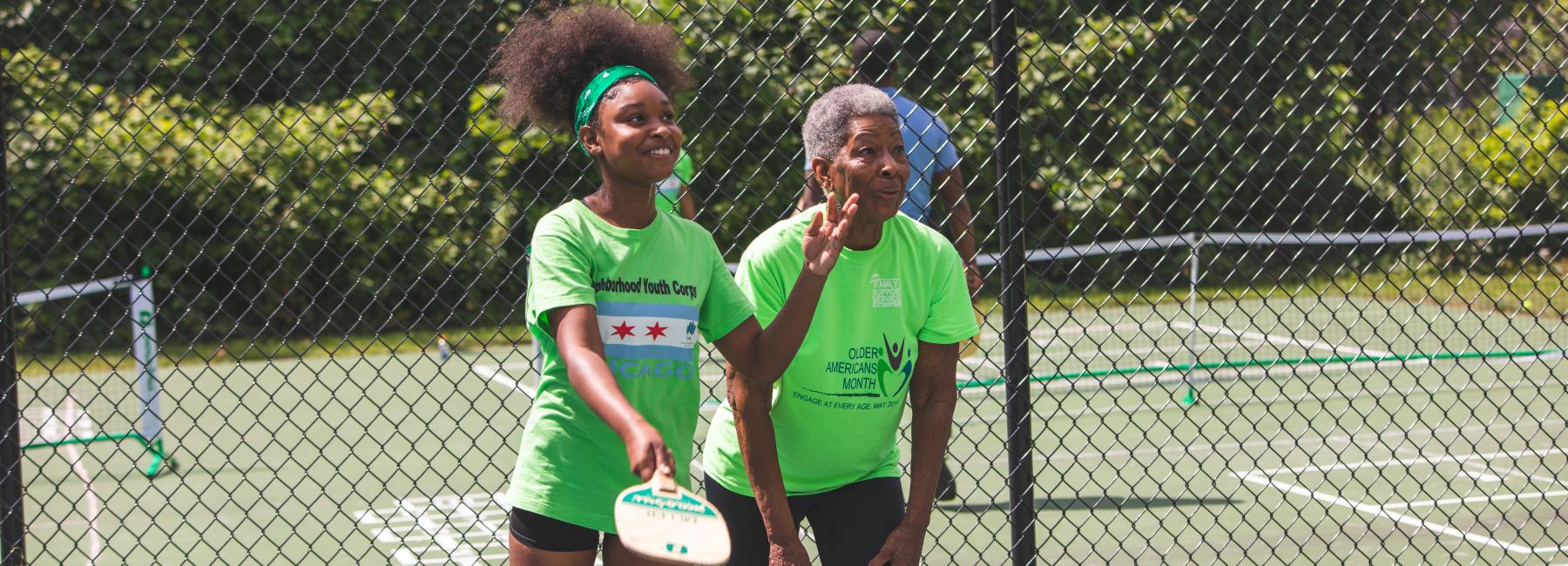 A CHA senior resident and youth enjoy a game of pickleball together