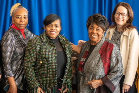 Board Members Francine Washington, Debra Parker, Dr. Mildred Harris, and Meghan Harte posed together in front of a blue backdrop.